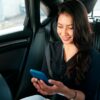 young latin businesswoman using smartphone in her car